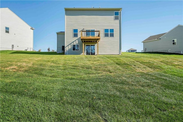 back of property featuring a wooden deck and a lawn