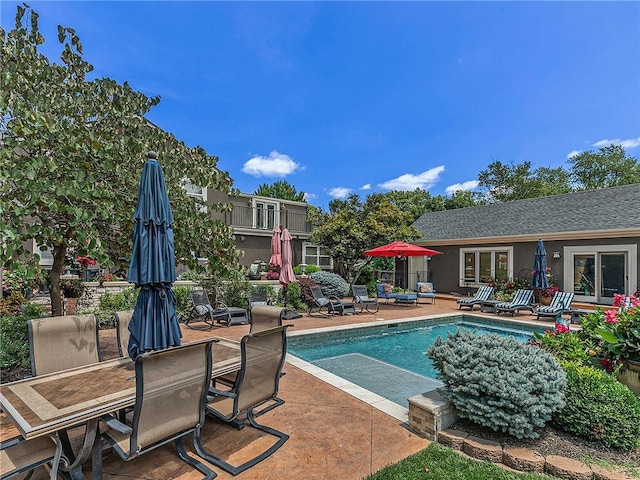 outdoor pool with a patio area and outdoor dining area