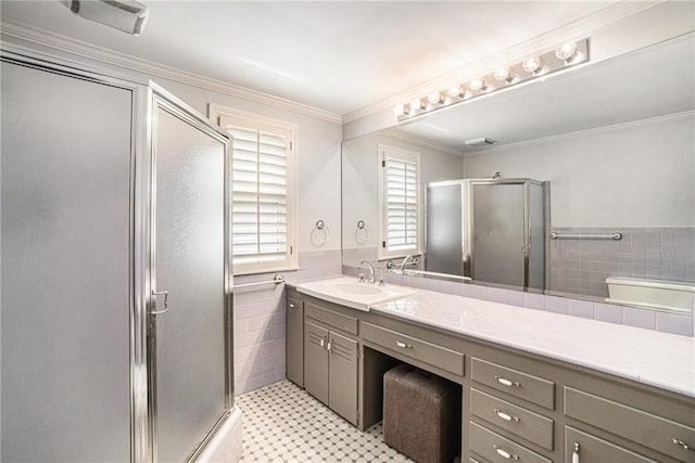 bathroom with tile walls, a shower stall, vanity, wainscoting, and tile patterned floors