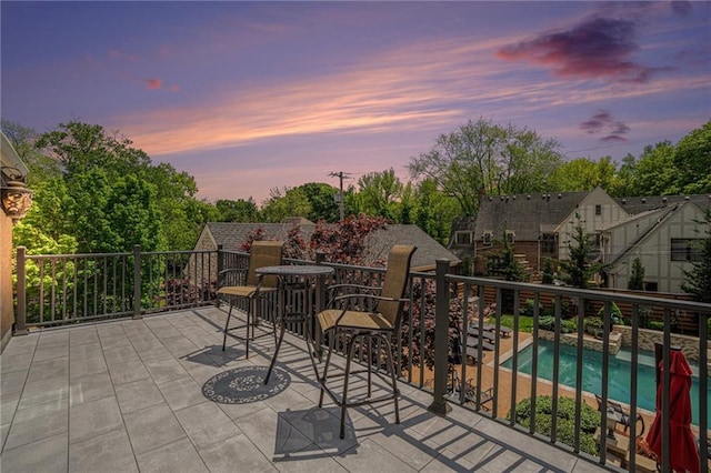 patio terrace at dusk featuring a balcony