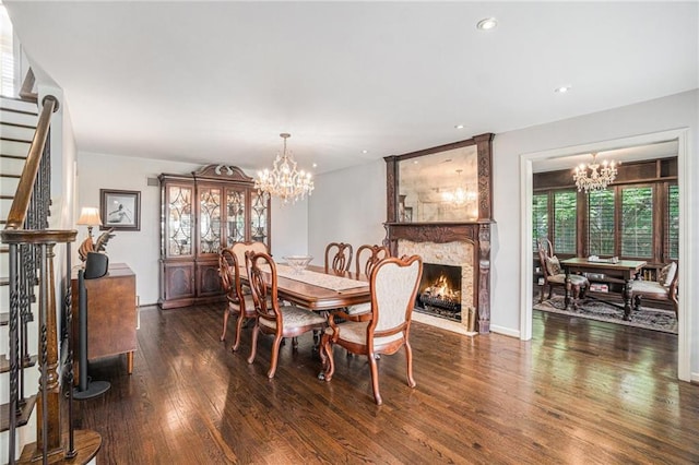 dining space with a chandelier, wood finished floors, stairs, recessed lighting, and a large fireplace