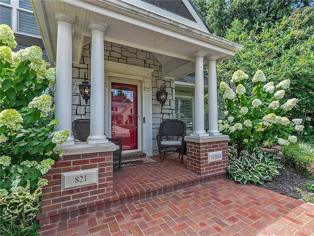 821 W 54th Ter, Kansas City, MO 64112 - view of exterior entry featuring a porch and stone siding
