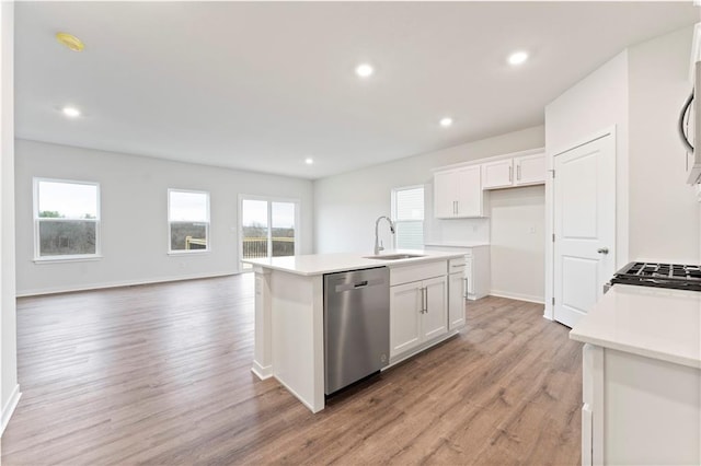 kitchen featuring white cabinets, sink, light hardwood / wood-style flooring, dishwasher, and an island with sink