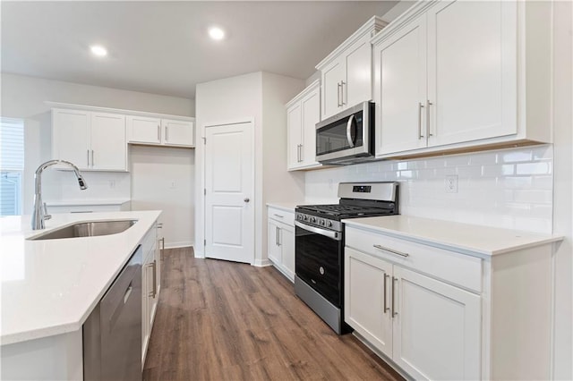 kitchen with white cabinetry, sink, dark hardwood / wood-style floors, decorative backsplash, and appliances with stainless steel finishes