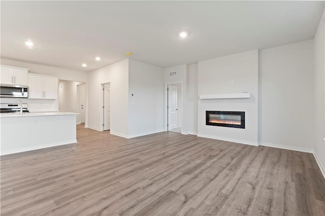 unfurnished living room featuring light wood-type flooring