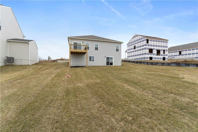 rear view of house with a lawn and central air condition unit