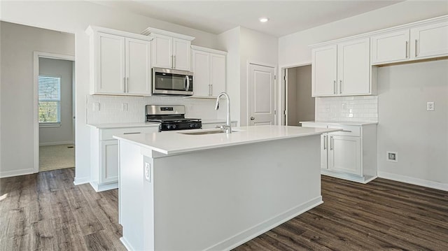 kitchen featuring appliances with stainless steel finishes, a center island with sink, and white cabinetry