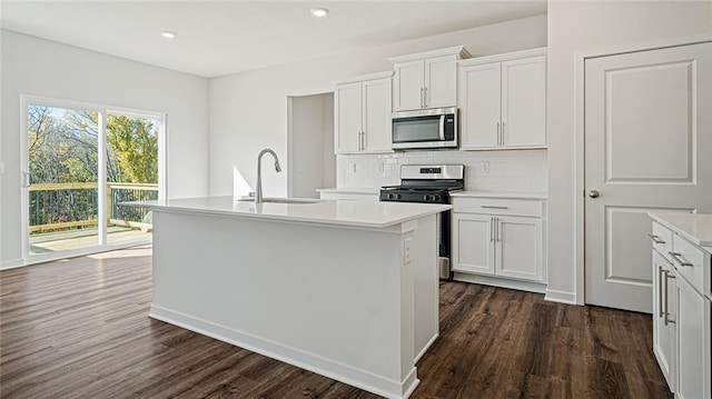 kitchen with sink, dark hardwood / wood-style flooring, a center island with sink, white cabinets, and appliances with stainless steel finishes