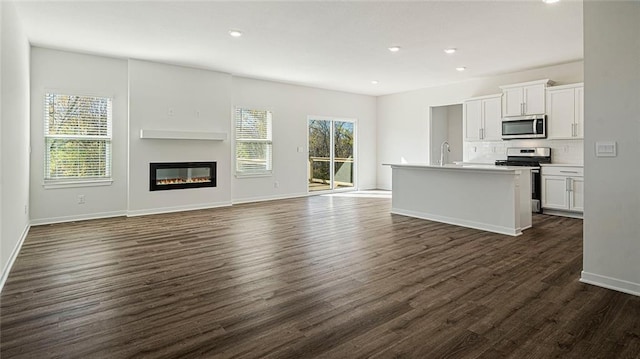 unfurnished living room with dark hardwood / wood-style floors and sink