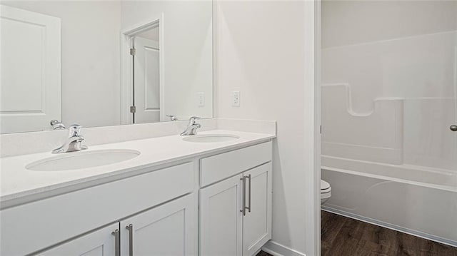 full bathroom with vanity, toilet, wood-type flooring, and bathing tub / shower combination