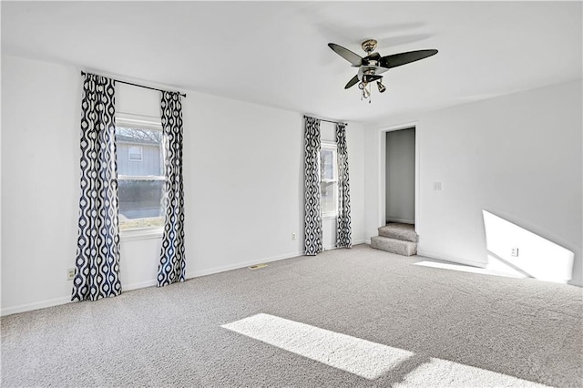 carpeted spare room featuring ceiling fan