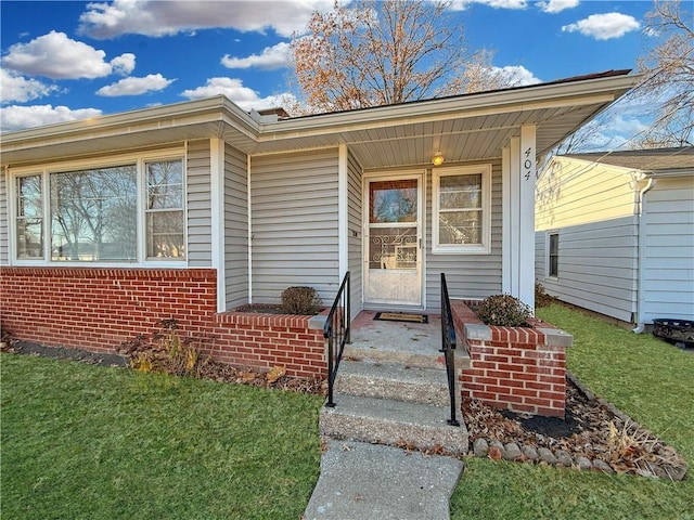 doorway to property featuring a lawn