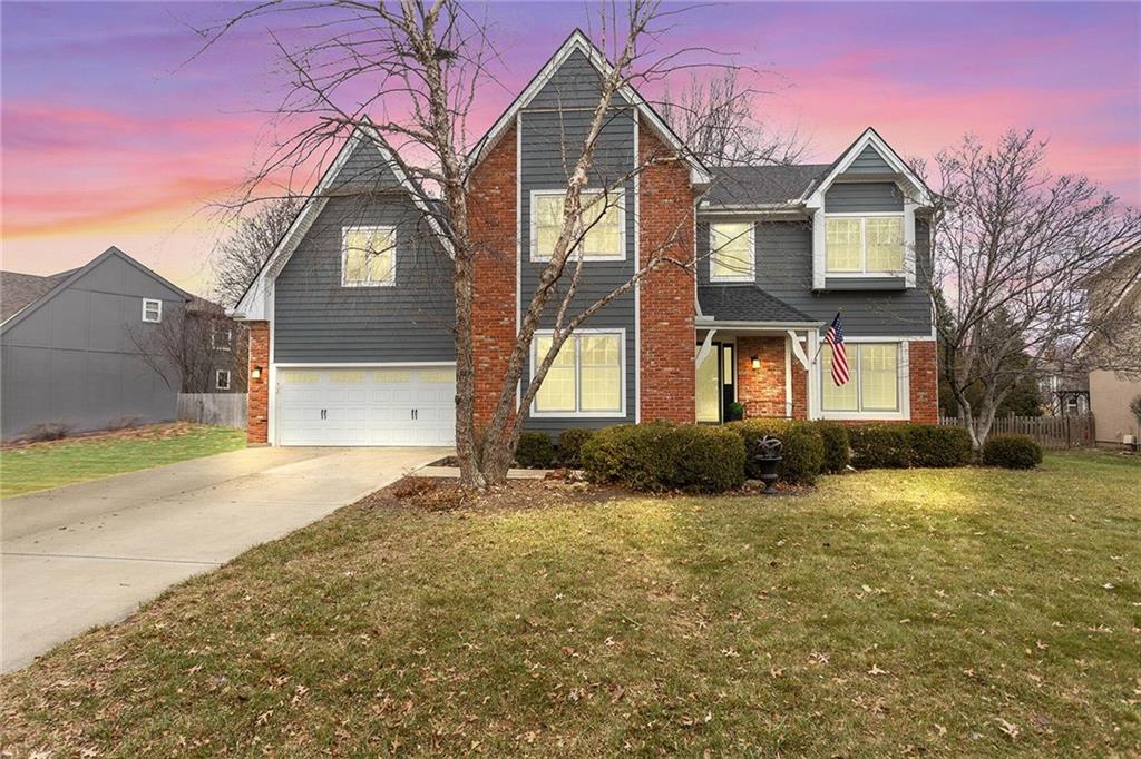 view of front of property with a garage and a yard