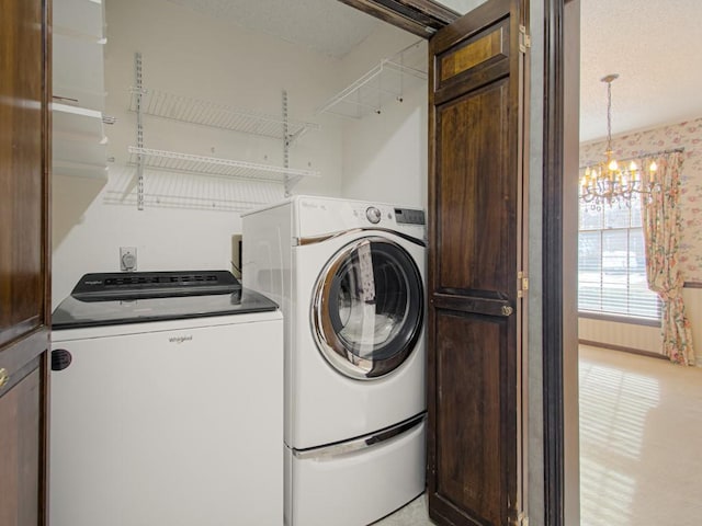 laundry area featuring washing machine and dryer and a notable chandelier