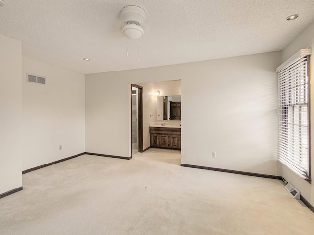 unfurnished room with light carpet and a textured ceiling