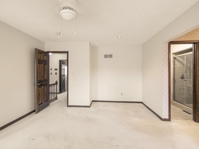 unfurnished bedroom with ceiling fan, light colored carpet, and a textured ceiling