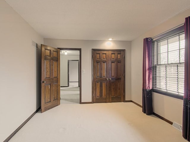 unfurnished bedroom with light carpet and a closet