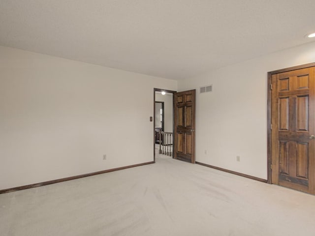 empty room featuring light colored carpet