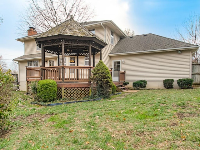 rear view of property featuring a gazebo, a deck, and a yard