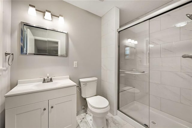 bathroom with vanity, toilet, and a shower with shower door