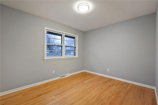 empty room featuring a textured ceiling and hardwood / wood-style flooring