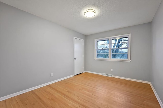 unfurnished room featuring a textured ceiling and hardwood / wood-style flooring