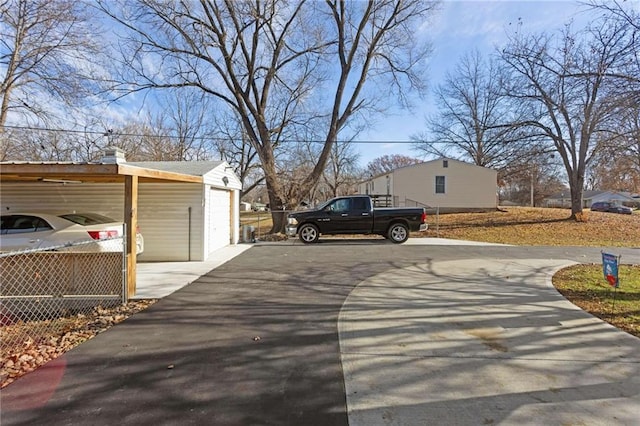 view of home's exterior with a carport, a garage, and an outbuilding