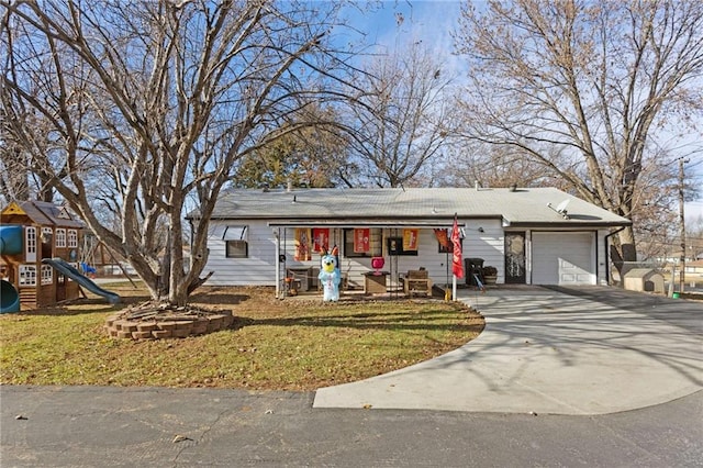 view of front of home featuring a front yard, a playground, and a garage