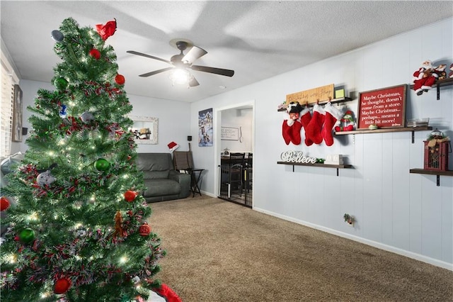 living room with carpet flooring, ceiling fan, and a textured ceiling