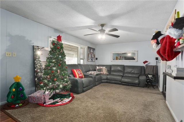 living room featuring ceiling fan, carpet floors, and a textured ceiling