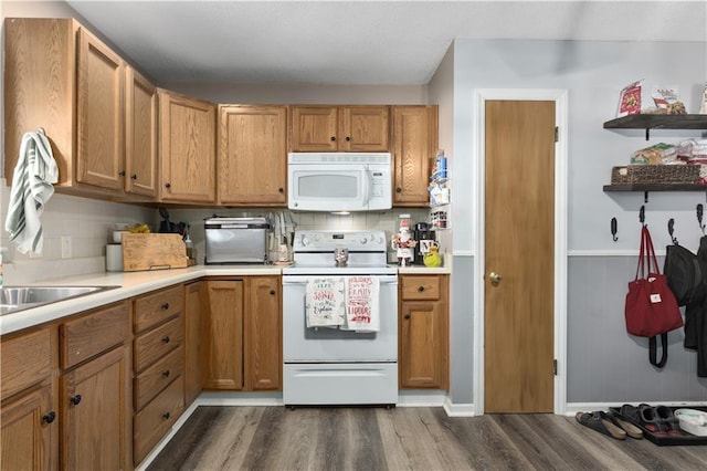 kitchen with sink, dark hardwood / wood-style flooring, white appliances, and backsplash