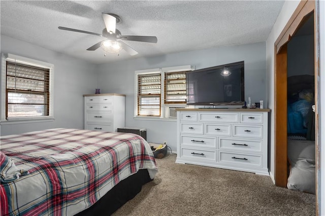 carpeted bedroom with ceiling fan and a textured ceiling