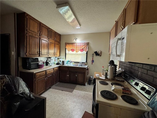 kitchen with sink, white appliances, a textured ceiling, and tasteful backsplash