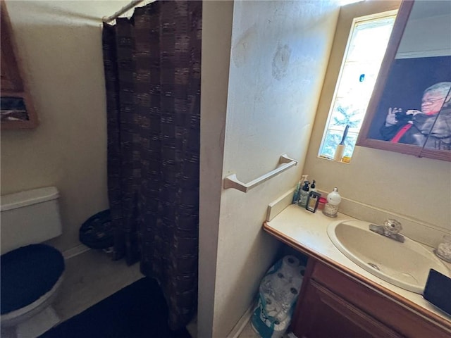 bathroom featuring vanity, curtained shower, and toilet