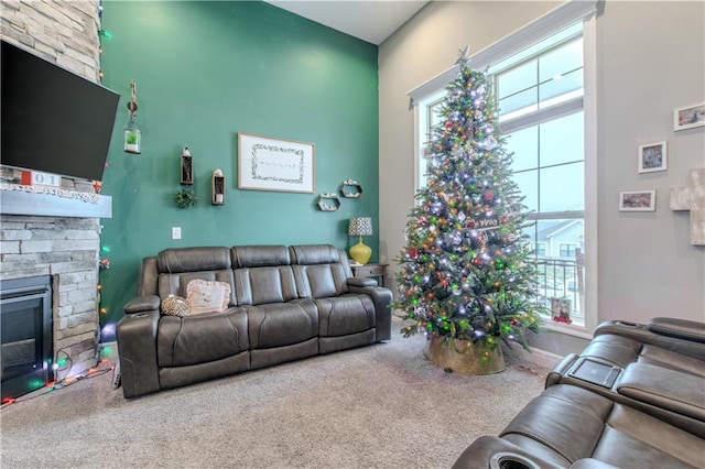 living room with carpet flooring and a stone fireplace