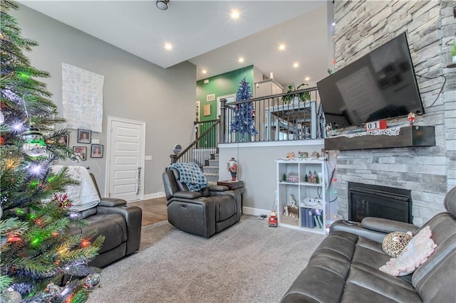 living room featuring carpet flooring, a fireplace, and a high ceiling