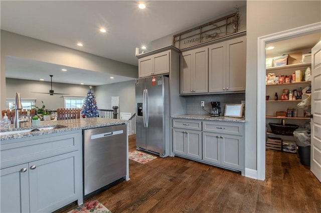 kitchen featuring light stone counters, gray cabinetry, stainless steel appliances, sink, and dark hardwood / wood-style floors