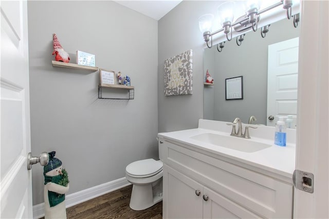 bathroom with toilet, vanity, and hardwood / wood-style flooring