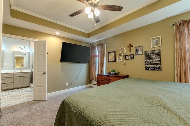 carpeted bedroom with connected bathroom, a raised ceiling, ceiling fan, and crown molding