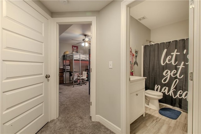 bathroom with a shower with curtain, ceiling fan, vanity, and toilet