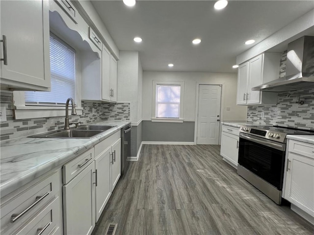 kitchen featuring white cabinets, stainless steel appliances, wall chimney exhaust hood, and sink