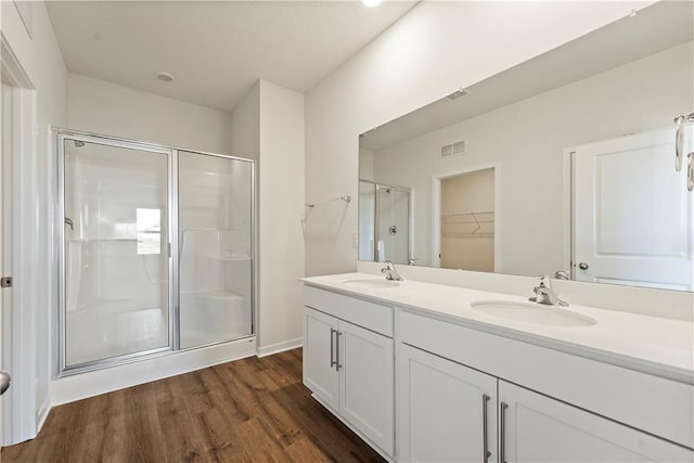 bathroom featuring hardwood / wood-style floors, vanity, and an enclosed shower