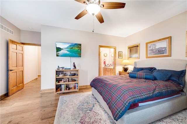 bedroom featuring ceiling fan, ensuite bathroom, and light wood-type flooring