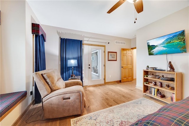 living room featuring light hardwood / wood-style flooring and ceiling fan