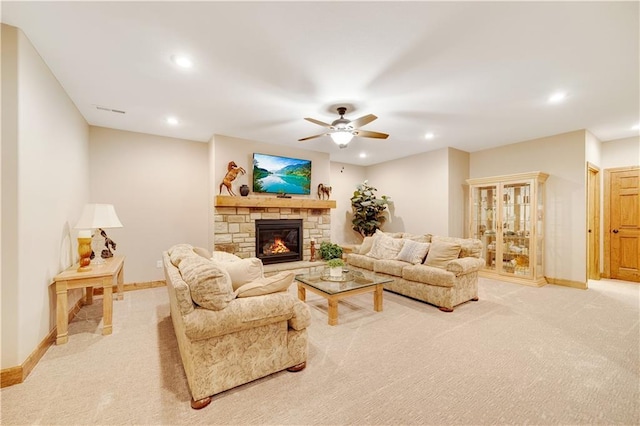 living room with a fireplace, ceiling fan, and light carpet