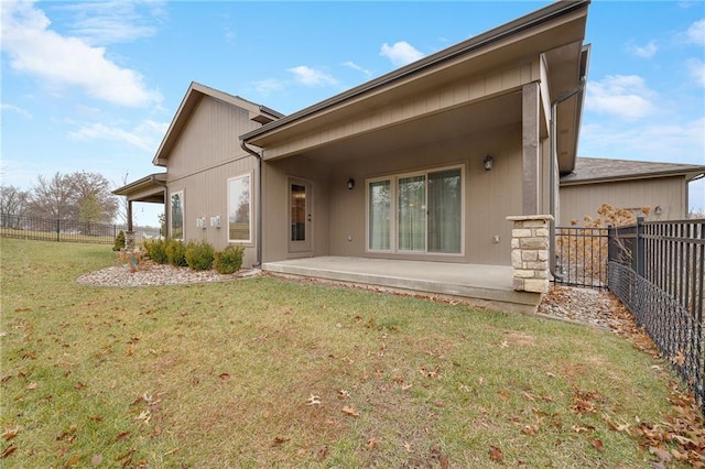 rear view of property featuring a lawn and a patio area