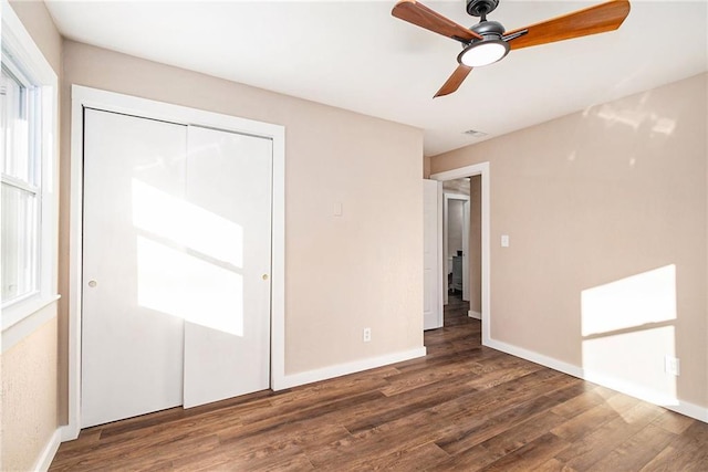 unfurnished bedroom featuring a closet, baseboards, and wood finished floors