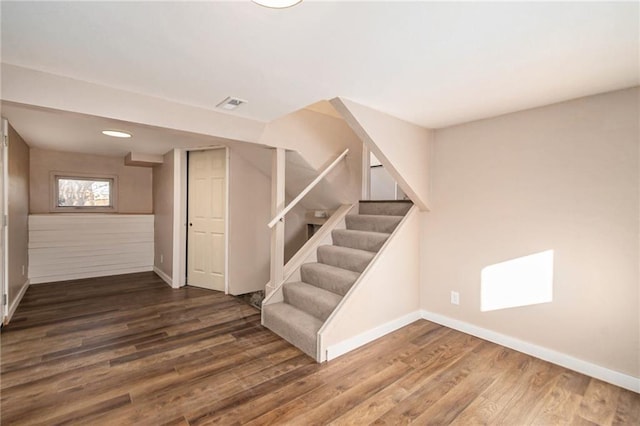 interior space with stairs, wood finished floors, visible vents, and baseboards