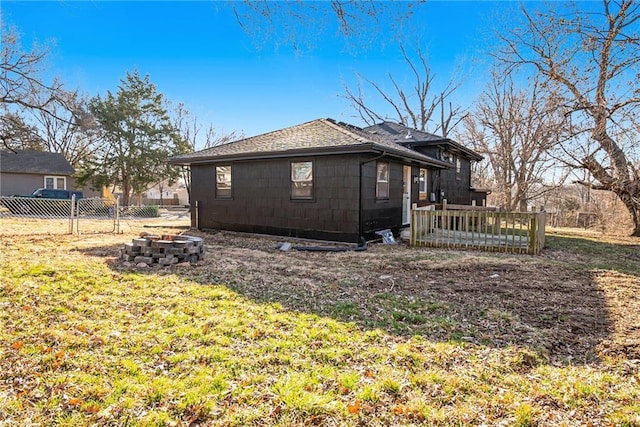 view of property exterior featuring a lawn, a fire pit, and fence