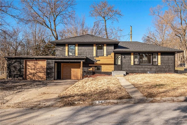 tri-level home with a garage, concrete driveway, and a shingled roof